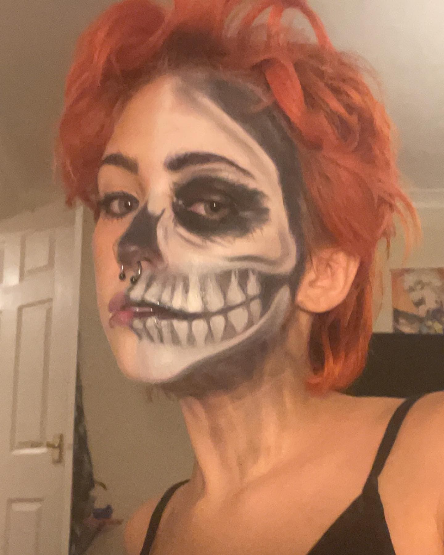 Half skull face paint with red hair.